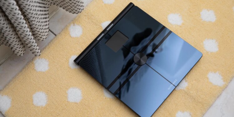Top-down view of the Withings BodyFit on a yellow bathmat with yellow polkadots.