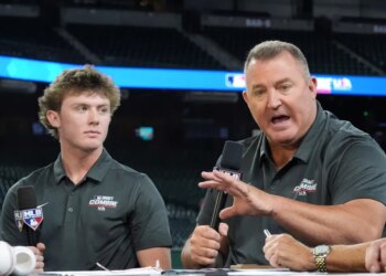 Jim Thome speaking at the MLB baseball combine with Landon Thome listening.