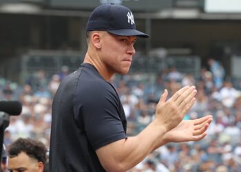 Aaron Judge clapping in the dugout during a Yankees-Twins game.