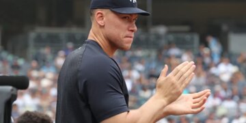 Aaron Judge clapping in the dugout during a Yankees-Twins game.