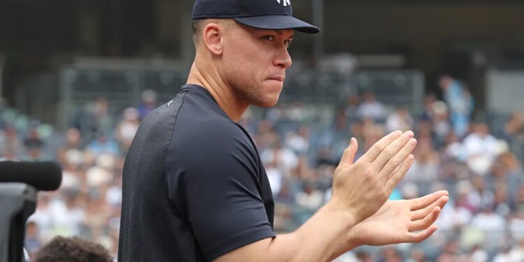 Aaron Judge clapping in the dugout during a Yankees-Twins game.