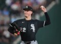 Noah Schultz, wearing a black White Sox jersey, mid-pitch during a baseball game.