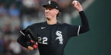 Noah Schultz, wearing a black White Sox jersey, mid-pitch during a baseball game.