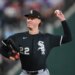 Noah Schultz, wearing a black White Sox jersey, mid-pitch during a baseball game.